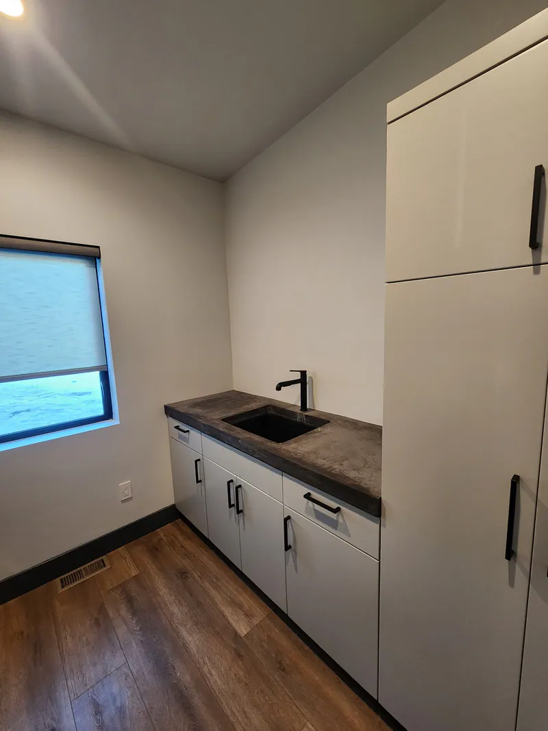 Concrete countertop in laundry room Huntwood cabinets, River Frontage Montana Style by Built Right in Montana