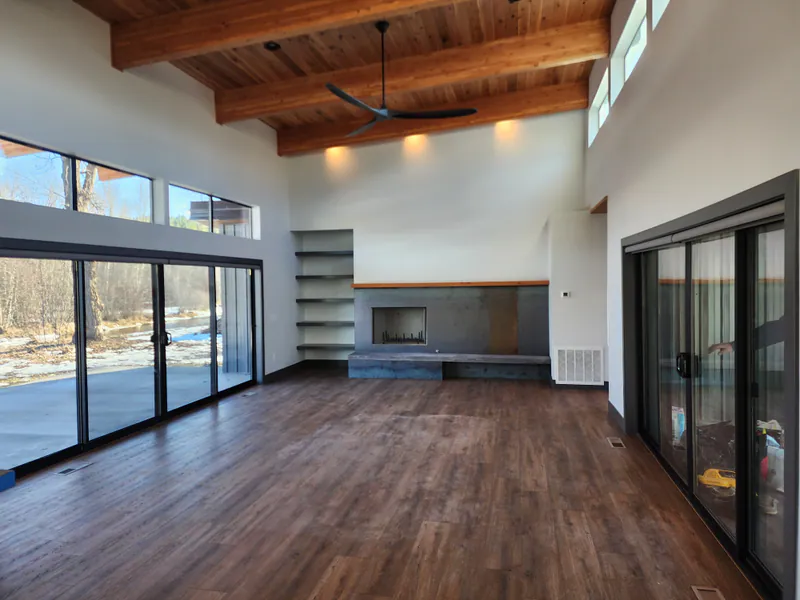 Open floor plan with metal faced gas fireplace and live edge cedar mantle, River Frontage Montana Style by Built Right in Montana