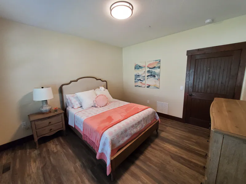 A bedroom with the trees outside, the Reese family home by Built Right in Montana
