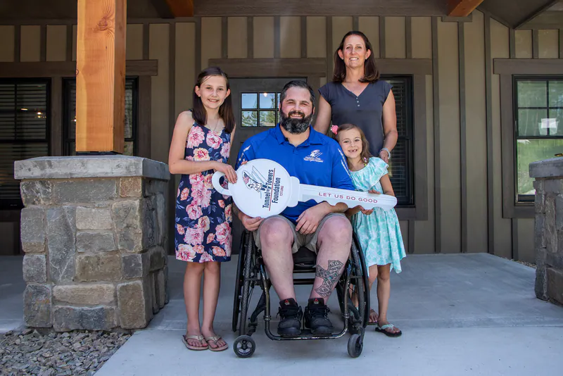 The Reese family on the porch of their new home, holding the Tunnel to Towers Foundation key